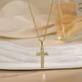 Détail du pendentif croix plaqué or serti de zircons sur un plateau décoratif blanc - Croix en Or Pavée Exquise (XL01909)