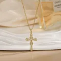 Détail d'un collier croix plaqué or avec cristaux scintillants sur un support blanc - Croix en Or Centre Noeud Infini (XL01910)
