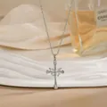 Gros plan d'un collier croix argentée avec pendentif papillon en cristal sur tissu satiné - Croix Argentée Papillon (XL01914G)