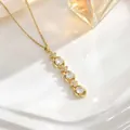Detail of gold tassel necklace featuring three round zircons and four-petal floral accents - Three Stones With Flower Accents Style (XL01933)