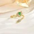 Macro detail of tulip ring featuring a green teardrop stone and zircon-encrusted gold petals - Emerald Green Teardrop Stone Style (JZ0470F)