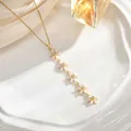 Detailed view of long gold tassel necklace with white floral pendants and zircon inlays - Five MOP/Artificial Pearl Flower Style (XL01937)