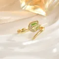 Close-up of golden tulip ring with green gemstone and pavé diamonds on wavy backdrop - Green Tulip Style (JZ0471D)