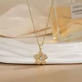Detail view of gold rotating flower pendant with sparkling zircons on a thin chain - 18K Gold Hollow Five-Petal Flower Style (XL02155)