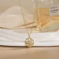 Detailed close-up of a rotating flower pendant on a gold titanium steel necklace - Hollow Round Floral Style (XL02156)