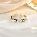 Macro detail of golden evil eye ring with blue enamel and sparkling zircon stones - Evil Eye Enamel Style (JZ0435)