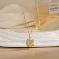 Close-up of golden spinning flower necklace with marquise crystals on a ceramic plate - Six Marquise Cut Floral Style (XL02170)