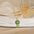 Gold titanium necklace with rotatable green zircon flower pendant on a display stand - Emerald Petal Daisy Style (XL02206)