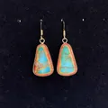 Macro view of trapezoid natural stone earrings with gold metal frame and ethnic pattern - 16x30mm / Colorful