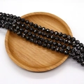 Polished black abalone shell beads with colorful mosaic inlay on a natural wooden tray - Black Iridescent Inlay (No. 6)