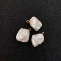 Set of three baroque pearl pendants with gold edges on black mesh background - White