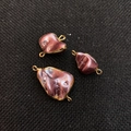 Tre ciondoli in conchiglia naturale viola barocca con bordi dorati e doppio gancio - Rosa