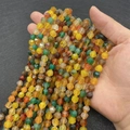 Perle di agata sfaccettate multicolore per gioielli fai da te tenute in una mano - Agata Giallo Verde