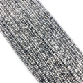 Macro detail of faceted natural stone beads with grey and black textured patterns - Map Stone