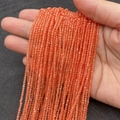 Strands of 2mm faceted orange cat eye stone beads held in hand for jewelry making - Orange Red (No.6)
