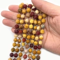 Faceted multi-color natural stone beads for DIY jewelry making held in hand - Yellow Jasper
