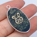 Ovale hanger van natuursteen met groene textuur en gouden konijn-motief detail - Musoogsteen Konijnenpatroon