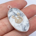 Ovale zilveren hanger met witte turquoise steen en gouden konijn-bedeltje sieraad - Witte Turkoois Konijnenpatroon