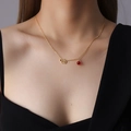 Minimalist gold necklace with hollow cloud pendant and red agate bead on a model - Gold Cloud Style