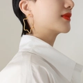 Minimalist 18K gold plated stainless steel star stud earring worn by a model - Large / Gold