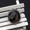 Handmade wire wrapped natural agate ring with dark druzy crystal on a miniature white bench - Black