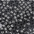 Macro view of black acrylic cube beads with white capital letters for DIY jewelry - Alphabet / 50 Pieces / Black with White Letters