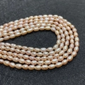 Macro detail of natural pink freshwater rice-shaped pearls with smooth luster texture - 3-4mm / Pink