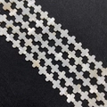 Macro detail of natural white mother of pearl cross shaped beads with iridescent luster - Cross