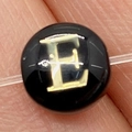 Macro detail of round black bead with golden letter E for DIY jewelry making - Letter E / 8mm