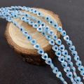 Macro shot of heart-shaped evil eye shell beads for DIY jewelry making on wooden base - Vertical Hole Heart Shape / Small