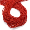 Vista macro di più fili di piccole perle tonde rosse in conchiglia naturale per gioielli DIY - Rosso Arancio