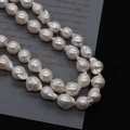 Detail macro-opname van onregelmatige witte barokke zoetwaterparels voor DIY-sieraden - 12-13mm / Witte Staartparel