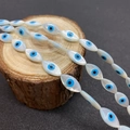 Macro detail of teardrop sea shell beads with blue evil eye pattern for DIY jewelry - Marquise Shape / Mini Type