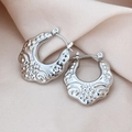 Gros plan sur des créoles argentées vintage avec reliefs floraux sur satin soyeux - Style Creux Texturé / Pack de 1 paire / Acier