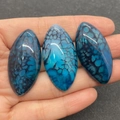 Trois pierres d'agate bleue veine de dragon en marquise tenues en main pour voir la taille - N°3 (Agate Veine de Dragon Bleue)
