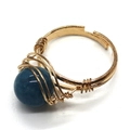 Détail de la bague artisanale en fil doré avec une pierre naturelle bleue de 10 mm - Perle Bleue (3)