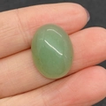 Polished 15x20mm oval green aventurine stone held in fingers showing its size and translucency - 15x20mm 4g/Piece / Green Aventurine