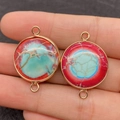 Handheld view of gold-rimmed round natural stone connector with red and green textures - Style 12 Red Green Contrast