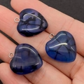 Close-up of three blue crackle agate heart pendants with silver metal loops on a palm - Dark Blue Style (4)