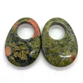 Macro view of polished teardrop unakite pendants with circular cutouts and unique textures - Unakite