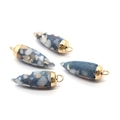 Dettaglio macro di quattro pendenti turchesi a forma di proiettile con cappucci dorati - Grigio Blu (No.2)