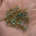 Golden chain with sky blue natural stone beads held in hand for size visualization - 10m/Roll / Style 4 (Blue)