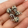 Dalmatian Jasper faceted stone pendants with silver metal loops held in hand - Dalmatian Jasper