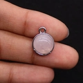 Detail macro shot of a round rose quartz pendant with a polished silver-plated bezel frame - 12x15mm, 2g / Rose Quartz