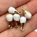 Five teardrop-shaped white turquoise pendants with gold clasps displayed on a hand - Howlite Style (5037910906842)