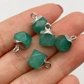 Set of five green faceted natural stone pendants with silver metal clasps held in hand - Green Aventurine