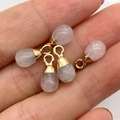 Handheld view of four rose quartz teardrop pendants with gold caps for DIY jewelry - Rose Quartz Gold Cap Style (5037910906844)