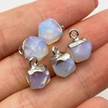 Five small faceted opal stone pendants with rainbow sheen held in hand for jewelry making - Opal