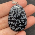 Sneeuwvlok obsidiaan druppel hanger met zilveren oogje in de hand - Sneeuwvlokobsidiaan