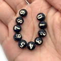 Primo piano di perline di conchiglia nere con numeri d'oro 0-9 per gioielli DIY - 8mm / Set Numeri 0-9 / Confezione da 10 / Nero